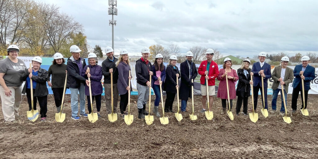 The Recipe for Hope Cabinet stands with shovels on new The River's land